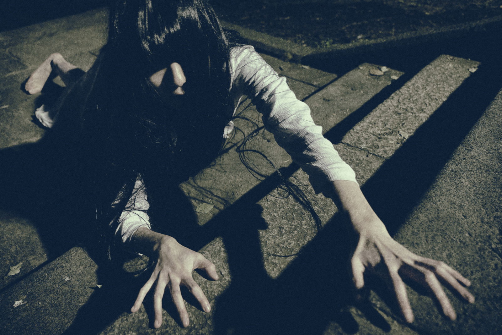 石畳の階段で這いつくばりながら手を伸ばして何かを探している女性［モデル：緋真煉］