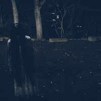 真夜中の広場で項垂れる白いワンピースの女性の写真