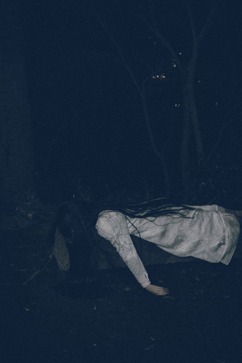 汚れた装いでうつ伏せに倒れこむ不気味な女性