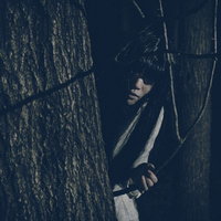 物陰からじっと見つめてくる女性の不気味な視線の写真