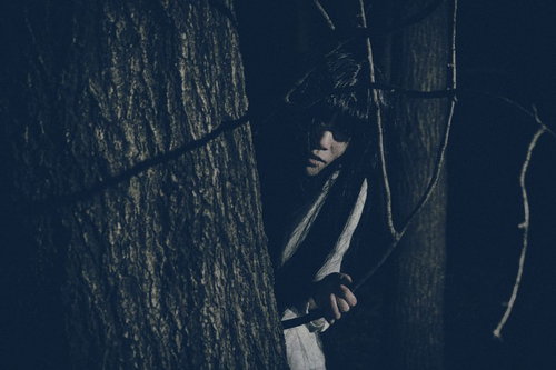 物陰からじっと見つめてくる女性の不気味な視線