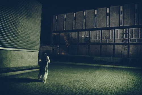 捕まったらゲームオーバー。夜の建物で振り返る白い服の女性