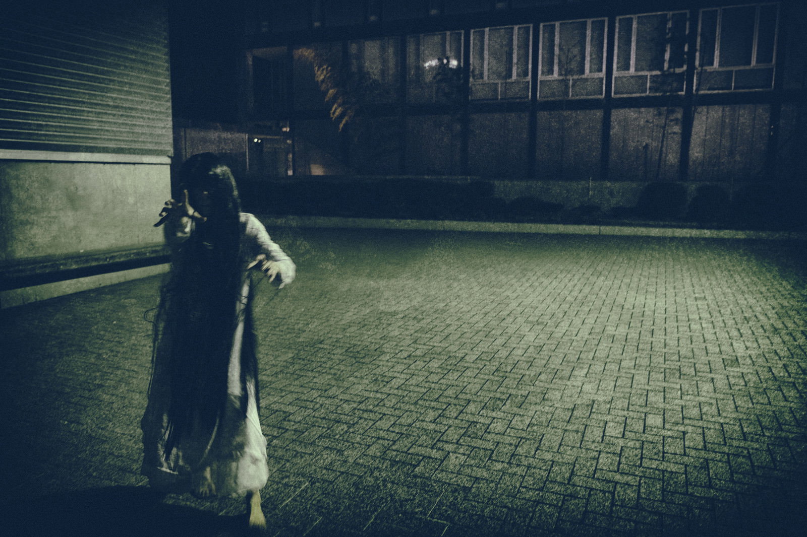 薄暗い石畳の通りで追跡者から逃げる女性のシルエット［モデル：緋真煉］