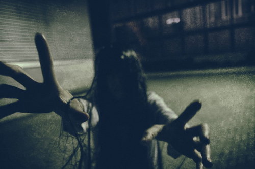 薄暗い空間で何者かにハグされる女性・怨念ハグ