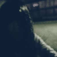 暗がりの中で髪を振り乱す女性の写真