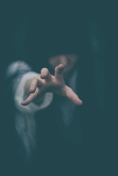 決して逃れられない恐怖に手を伸ばす女性の呪いの瞬間