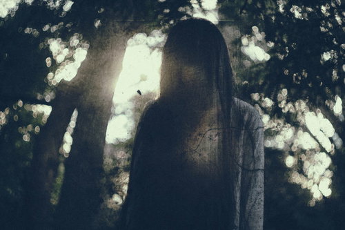 暗い森の中で呪いをかけられた女性のシルエット