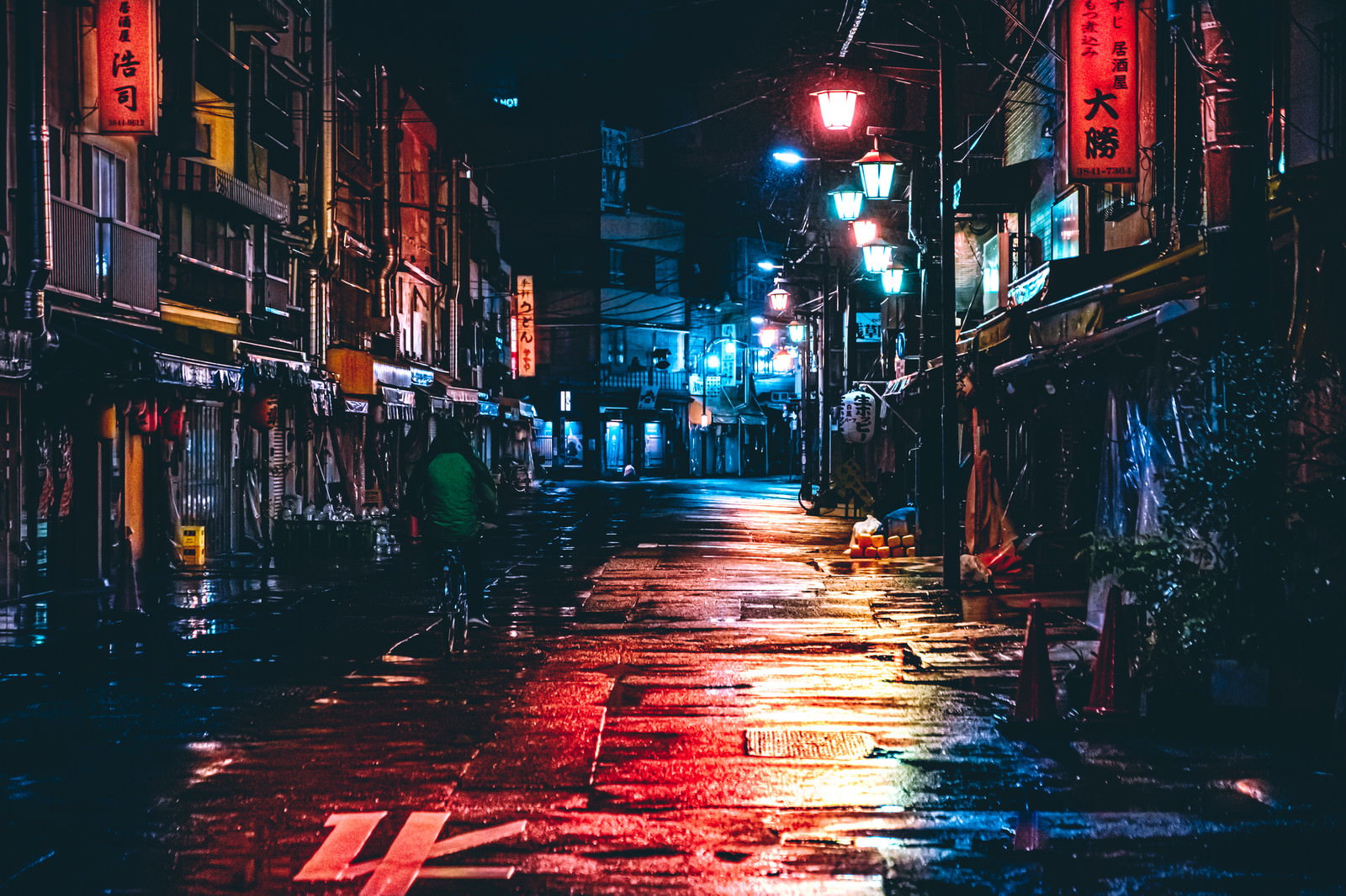 雨上がりの夜の路地裏でネオンサインの光が濡れた路面に反射している夜景
