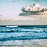 引いては寄せ、寄せては返す波がオールドレンズで捉えた砂浜の写真