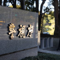 警視庁の入り口を警備する制服姿の警察官の写真