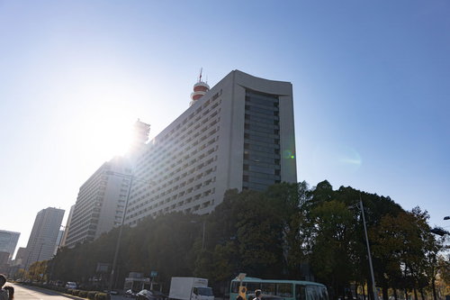 青空を背景に太陽光で照らされた警視庁本部庁舎