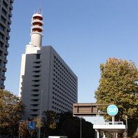 青空の下に建つ警視庁本部庁舎と煙突の写真