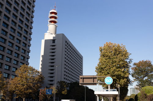 青空の下に建つ警視庁本部庁舎と煙突