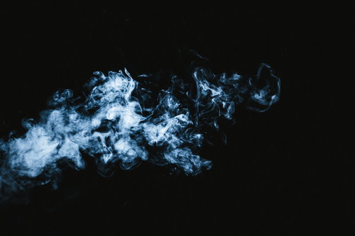 黒い背景に立ち上る霊魂のような青い煙のホラー背景