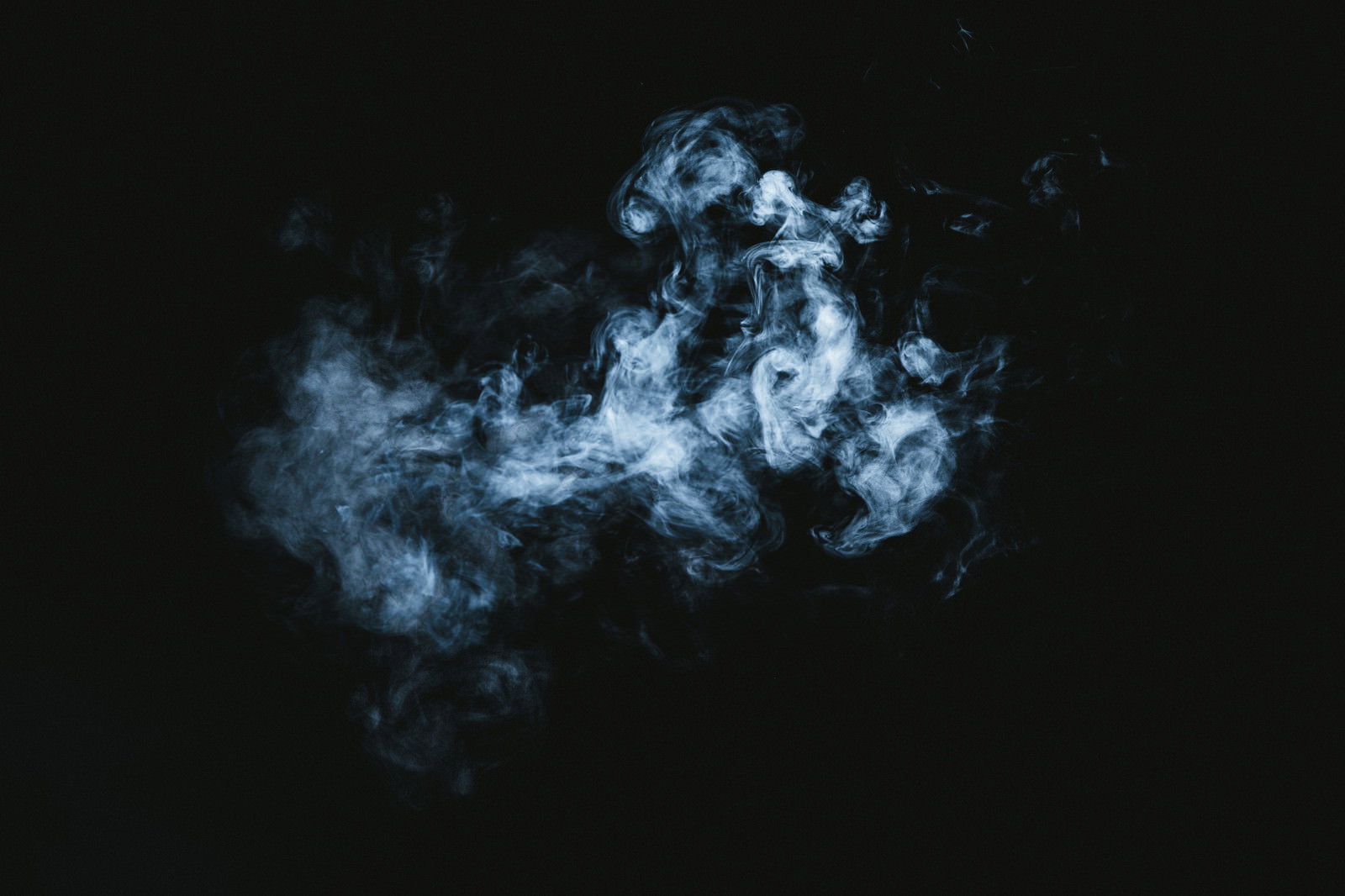 暗闇の中で渦巻く青白い煙