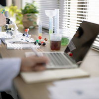 試行錯誤しながら論文を書く研究員と実験用機材の写真