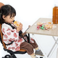 ベビーカーに座る子どもとおやつを楽しむ親子の写真