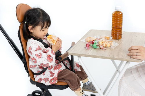 ベビーカーに座る子どもとおやつを楽しむ親子