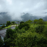 芦ヶ久保から望む雨雲に覆われた山々の景観の写真