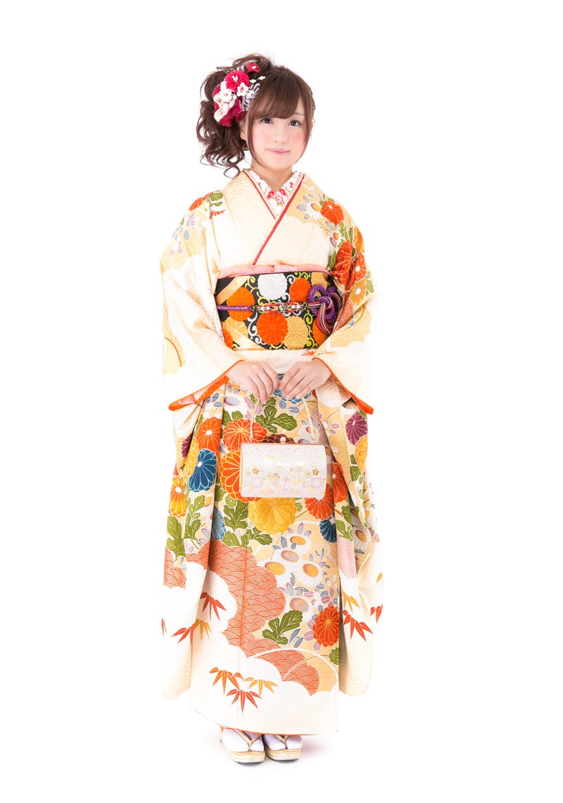 白地花柄の振り袖に赤い花飾りをつけた女性の全身［モデル：河村友歌］