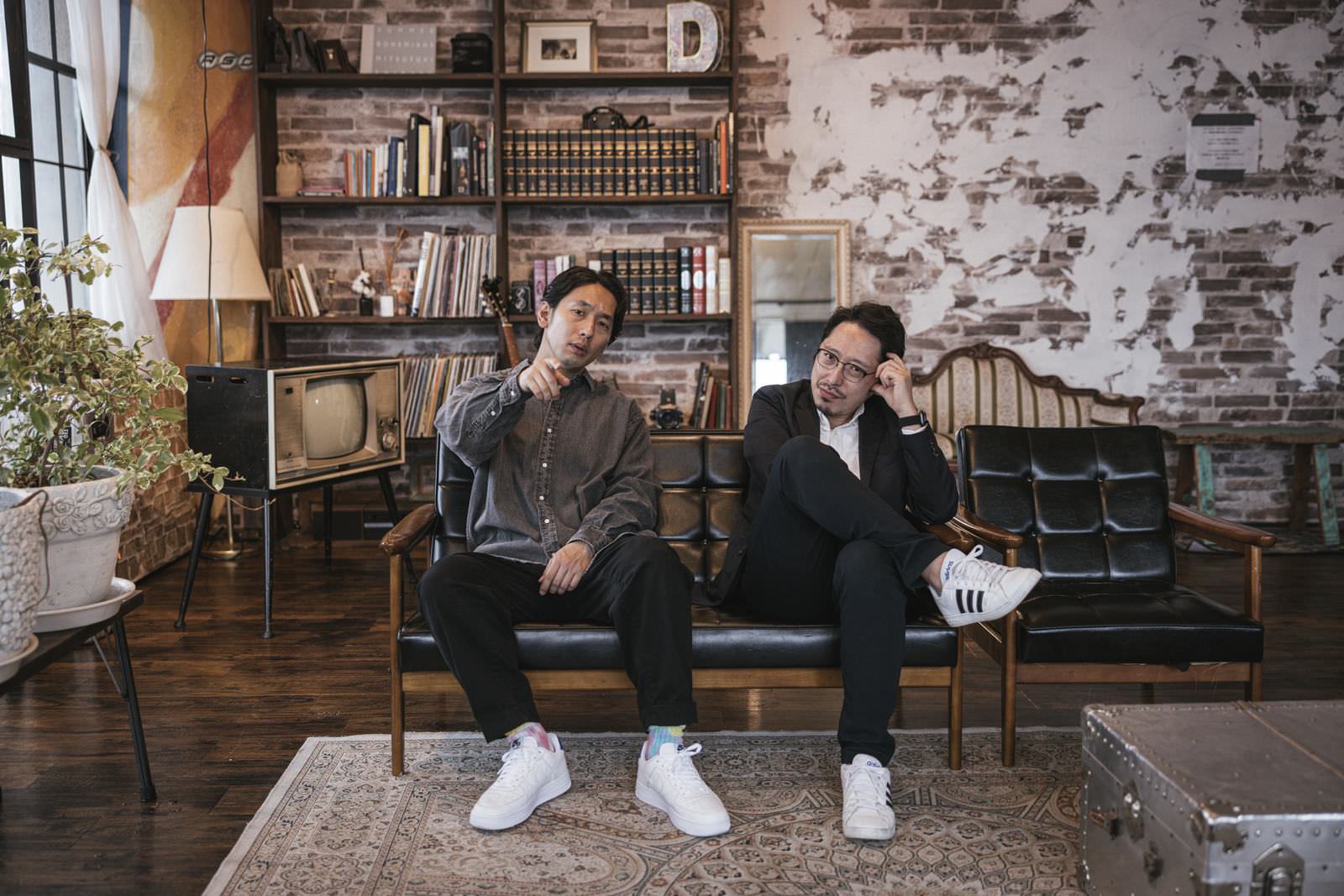 ソファに座り威圧的な雰囲気を放つコンサルタント男性2人［モデル：ゆうせい 大川竜弥］