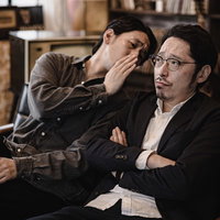 相方にこっそり耳打ちして秘密の情報を教える男性の写真