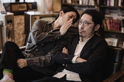 相方にこっそり耳打ちして秘密の情報を教える男性