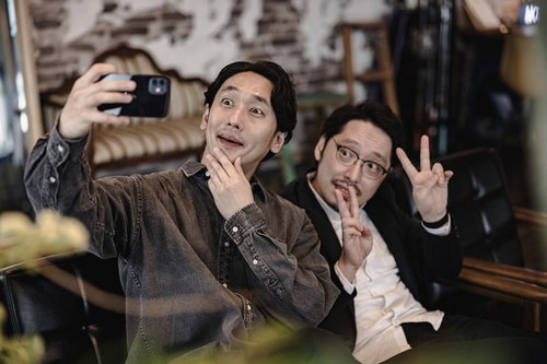 スマートフォンでピースサインをしながら自撮りするアラフォーのふたり