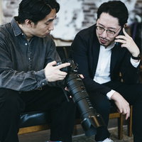 証拠写真を確認しながら依頼人に電話する探偵の二人の写真