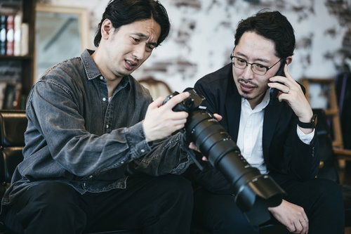 難しい顔でスクープ写真を確認する二人組の男性