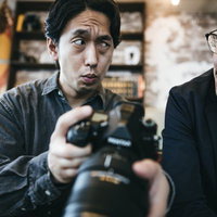 クライアントに写真の出来を確認する男性カメラマンの写真