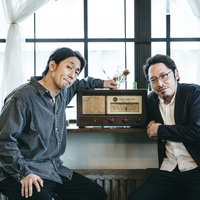 レトロなラジオから流れるBGMを聞く調査員の男性の写真