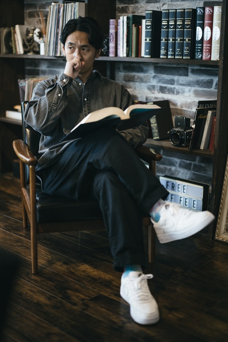 本棚に囲まれた書斎で椅子に座り読書をする男性［モデル：大川竜弥］