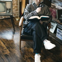 書斎で拡大鏡を使いながら書物を読む男性の文字確認の写真