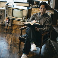 書斎で読書中に虫眼鏡を手にする男性の調べものの写真