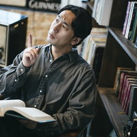 書斎で本を手に何かを思いつく男性、ひらめきの瞬間の写真