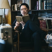 図書館で読書にふける男性が本を手に学習する様子の写真