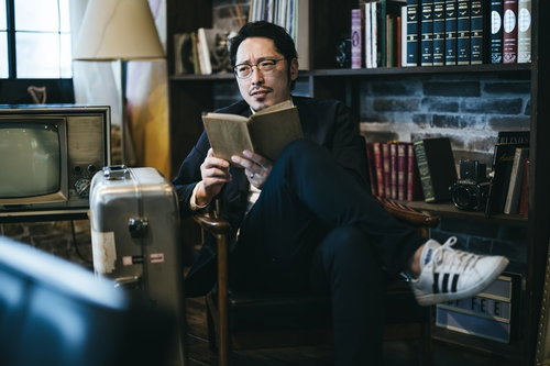 図書館で読書にふける男性が本を手に学習する様子