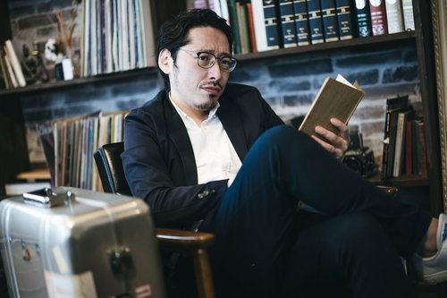 図書館で読書に集中できない眼鏡をかけた黒いスーツの男性