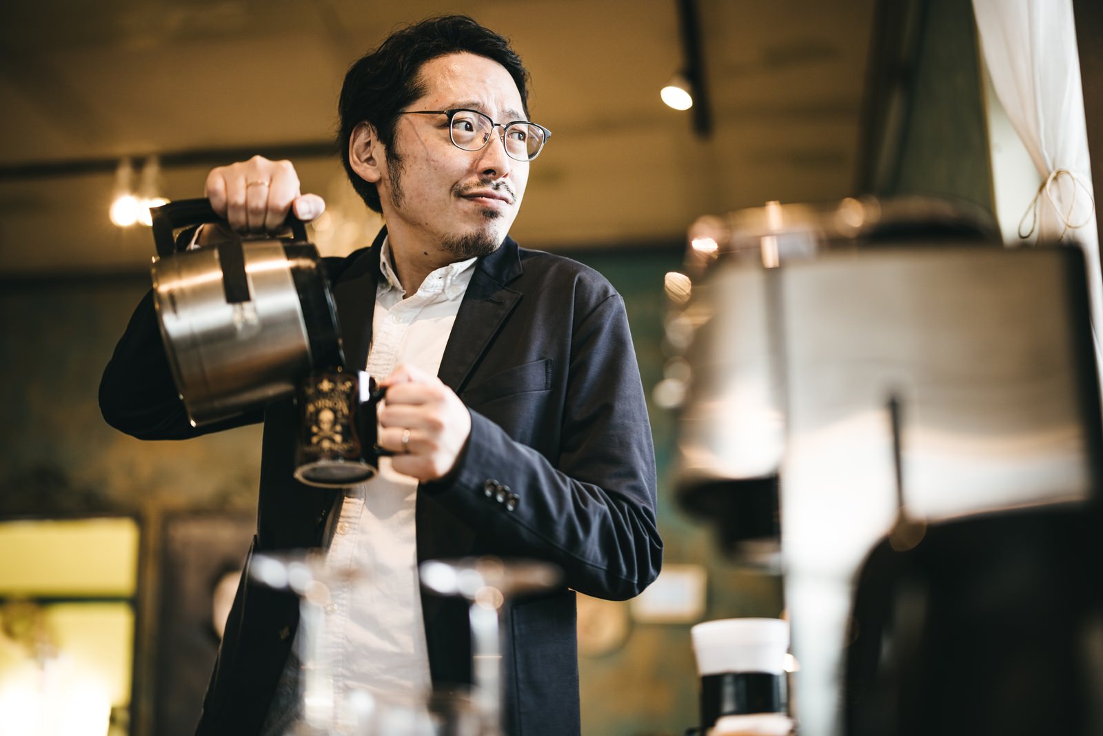 コーヒーカップを持ちながら考え込むスーツ姿の男性［モデル：ゆうせい］