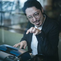 リズムに乗ってタイプライターをたたくご機嫌な男性の写真