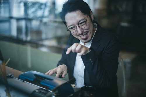 リズムに乗ってタイプライターをたたくご機嫌な男性