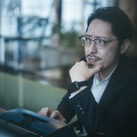 タイプライターの前で考え込む探偵男性メガネの写真