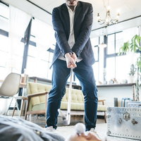 潜入がバレて気づけばこのザマ、スーツ姿でアイアンを握る男性の写真