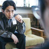 この白い粉に見覚えはないかと尋問する刑事男性の写真
