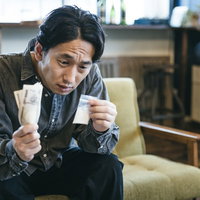 パケに入った白い粉を高値で購入する男性の犯罪捜査シーンの写真