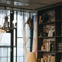 暖かい照明に照らされた洋書のある落ち着いた読書スペースの部屋の写真