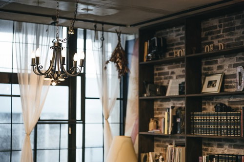 暖かい照明に照らされた洋書のある落ち着いた読書スペースの部屋