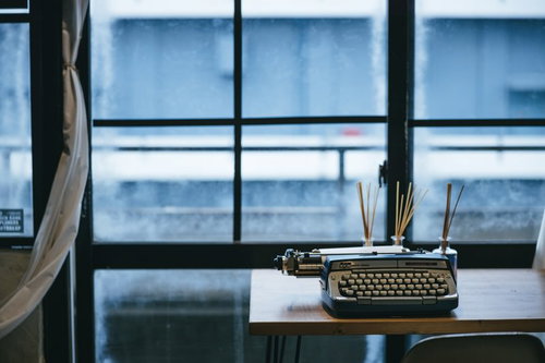 窓際のデスクに置かれたレトロなタイプライター