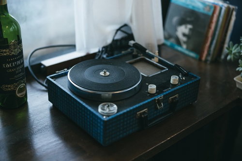 窓辺に置かれた黒いレコードプレーヤーとターンテーブル